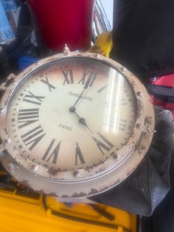 vintage-style round wall clock with an aged metal