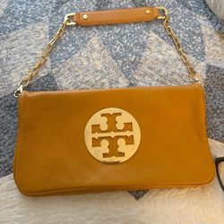 Tory Burch camel/tan leather shoulder bag featuring a gold-tone chain strap with leather shoulder pad and the signature round logo hardware on the fro