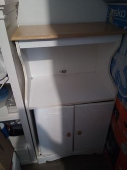 White cabinet with two doors and decorative palms set with holder