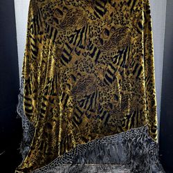 Animal-print shawl features a bold, mixed wildlife pattern—incorporating elements like leopard spots and tiger stripes—on a golden-yellow velvet backg