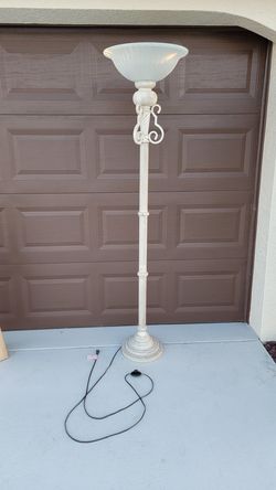 Vintage style torchiere floor lamp featuring a cream-colored, ornate base and a milk glass shade. 
Design: Torchiere lamps feature an open-top shade t