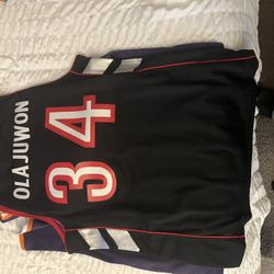 🏀 Mitchell & Ness Hakeem Olajuwon #34 – Raptors Throwback (Purple/Black) – Size Large