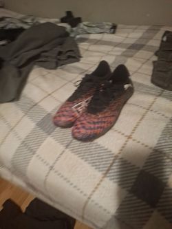 Puma Future 8 Play soccer cleats in a black, orange, and purple colorway