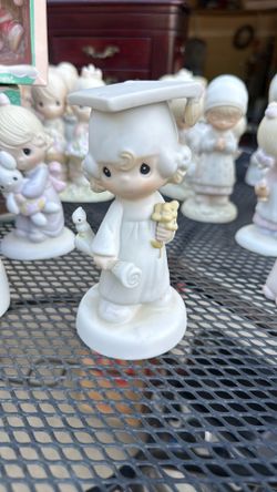 Precious Moments "The Lord Bless You and Keep You" graduation figurine, produced by Enesco in 1980.