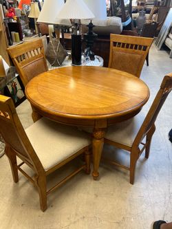 East West Furniture dining set features a round oak pedestal table and four matching chairs with a textured back design.