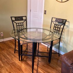 Ashley’s Black Iron Table With A Design In The Middle Of The Table With 4 Iron Black Chairs.