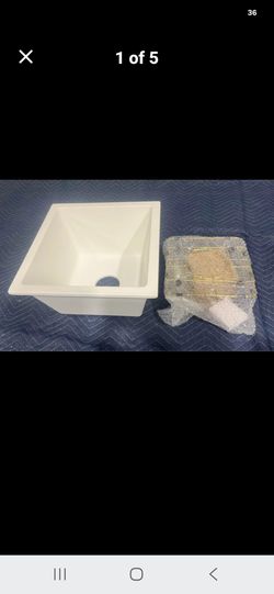 New white quartz kitchen sink is a single bowl model CS3838. It has a 9-inch depth and includes a gold-toned drain assembly and a matching bottom grid