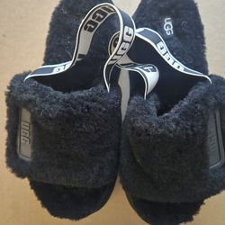 Black UGG slippers with white logo