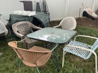 A set of 4 different chairs and a patio table (35” x 35”)