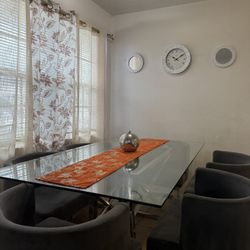 Elegant Glass Dining Table with 6 Grey Chairs.