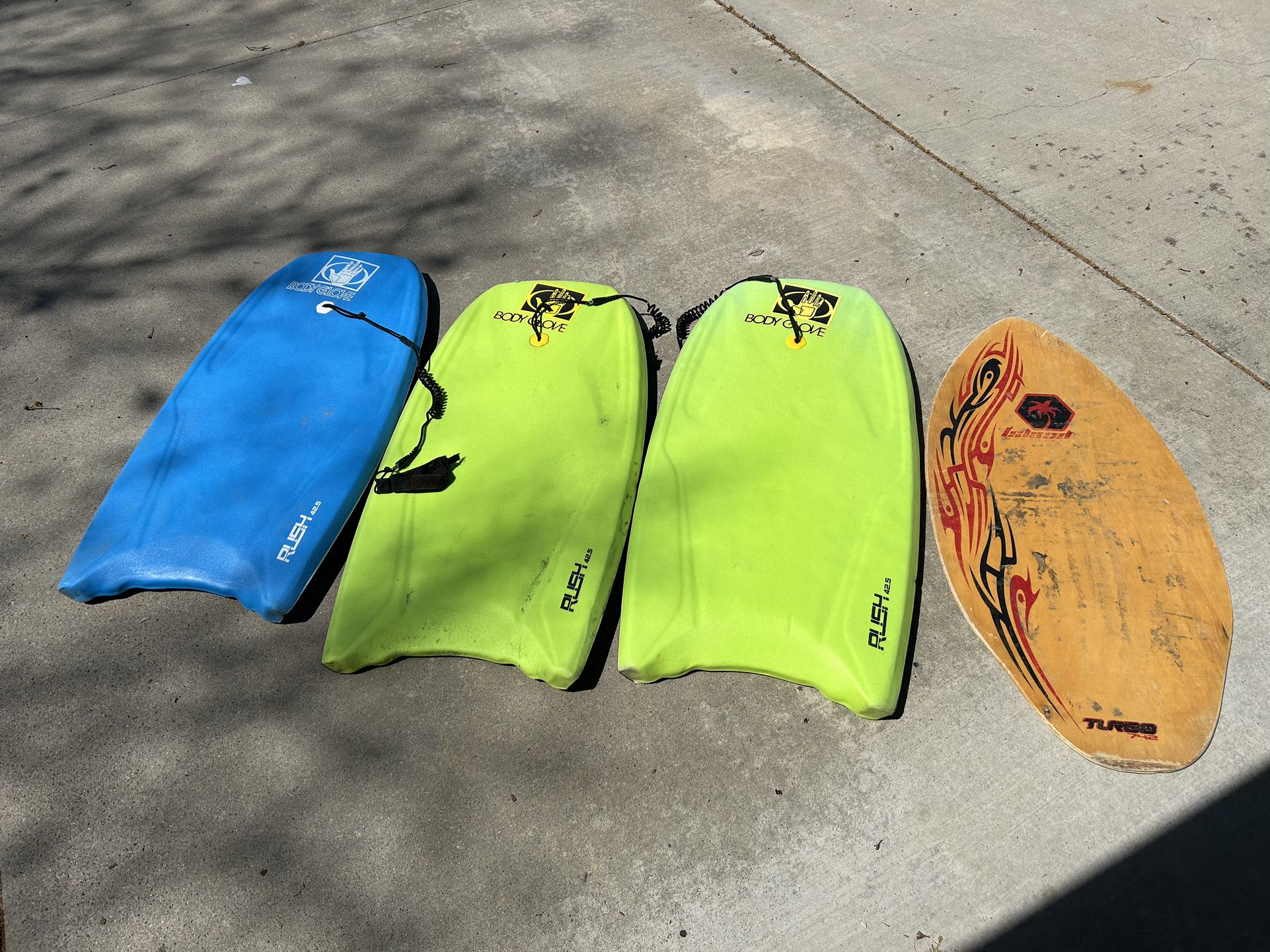 3 boogie boards and a skimboard 