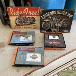 Three brand newHarley Davison picture frames and two metal signs