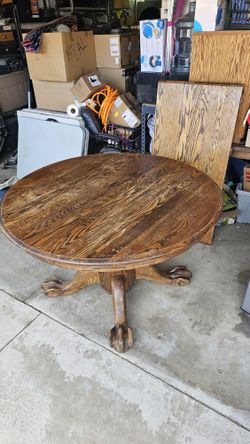 Solid wood table with claw feet expansion leaf.
