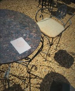 Beautiful wrought iron pub/bistro set for the patio or breakfast nook. Round GRANITE stone tabletop on an ornate scrollwork iron base, paired with two