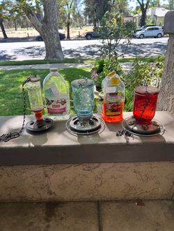 3 bird feeders and nectar