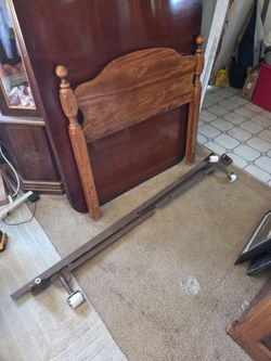 Twin size wooden headboard and metal rails, missing one wheel