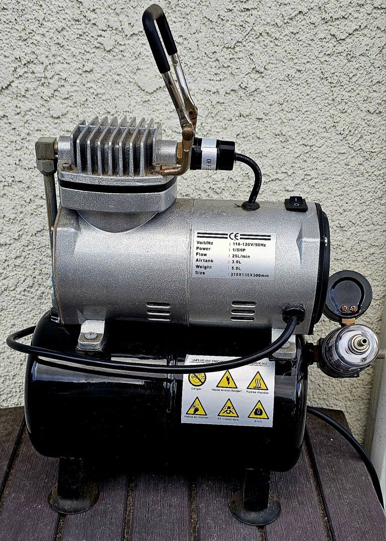 TC-20T airbrush compressor, a single-cylinder mini air compressor often used for hobbies and fine art. 
It features an automatic stop function and a 3