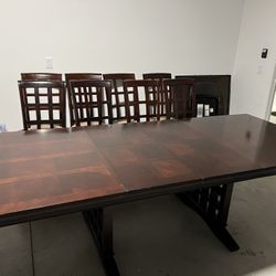 Large dinning table with 8 cushioned chairs made with rock solid,brown colour