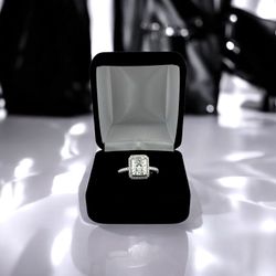 10kt White Gold with Radiant Center Cut Moissanite and Small Round Clear Stones Ring.