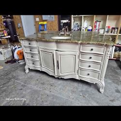 A Beautiful Vanity With Granite Top And Faucet 