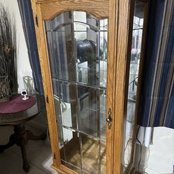 Vintage Glass Oak Curio Tiger Paw Cabinet With A Light On Top.