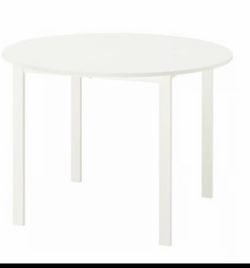mesa con cuatro sillas color blanco y sillas de madera