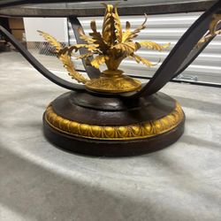 Large glass and metal  coffee table with golden decor in the center .. 5’ feet wide . 39 “ depth, . 23” high .. 