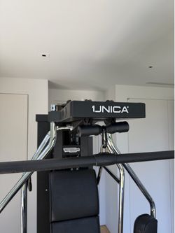 Technogym Unica home gym with separate bench and dumbbell set, peloton bike with screen