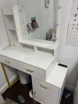 White & gold vanity with mirror Tocador blanco y dorado con espejo.
