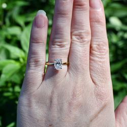 1.07 CT lab-grown oval solitaire engagement ring in 14K yellow gold with white gold prong tips. Includes IGI report.