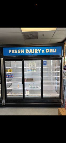 Hussmann 3-door commercial glass display refrigerator/freezer. Large upright merchandiser with glass doors and adjustable shelving.
