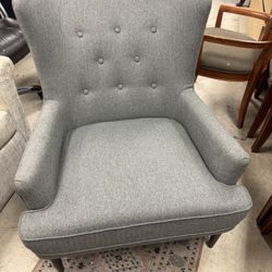 modern tufted wingback accent chair upholstered in light gray fabric with wooden legs