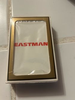 small, packaged item with a gold-trimmed box and the red text "EASTMAN" in a stylized font, which resembles branding associated with the Eastman Chemi
