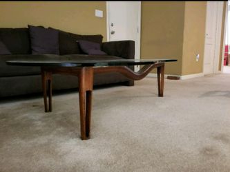 Glass top coffee table with a unique design. Wood base which is also very unique SERIOUS INQUIRIES ONLY