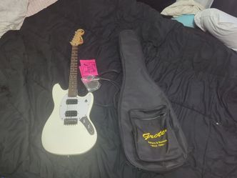 Squier Mustang HH electric guitar, 3 9 gauge strings,a backpack/carry soft case, and a 6 foot cable
