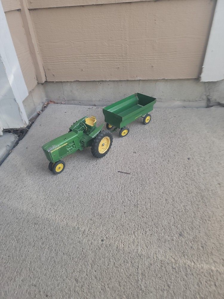 Collectible John Deere tractor with pull behind trailer circle 1950