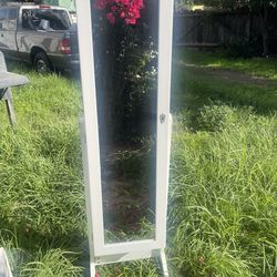 white freestanding mirrored armoire.