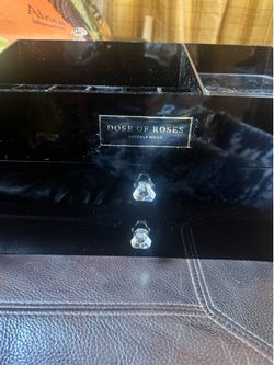 Sleek black acrylic jewelry organizer with clear crystal drawer pulls. Gold logo plaque reads 'Dose of Roses'. Multiple compartments for easy storage.
