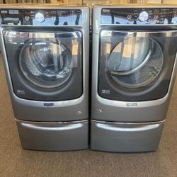 MAYTAG FRONT LOAD WASHER AND DRYER SET ON PEDASTALS 