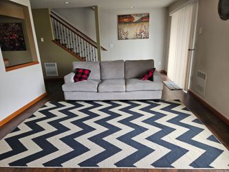 Sofa with rug and two cushions