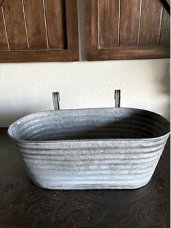 Galvanized Ridge Container features a rustic, oblong design with sturdy metal hooks for hanging