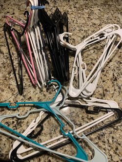 28 plastic clothes hangers in various colors & styles.