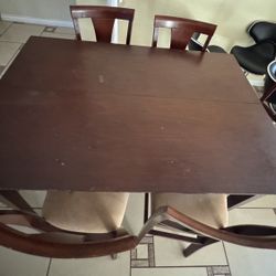 wooden dining table with a set of matching chairs