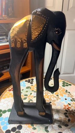 Artistic Large hand carved wood elephant with beautifully designed multiple brass accents on wood platform, and wood tusks