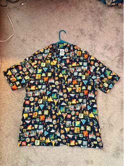 Premium Disney Parks Collection shirt by Tommy Bahama featuring a tropical postcard-style Mickey Mouse print. High-end, lightweight silk with a relaxe