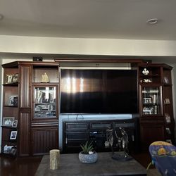 Five piece council bookshelf next to a TV two piece on each side and one on top 8 feet tall
