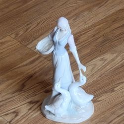 Vintage Lladro-style porcelain figurine girl feeding geese country girl 
peasant girl 10.5" tall. Pre-owned, very good shape, no chips or cracks. 
Ple