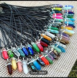 This 30-piece pendant set features colorful crystal stones in a pointed design, perfect for chakra healing. The black leather necklace adds a stylish