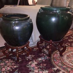 A pair of green porcelain pots on Cherrywood stands