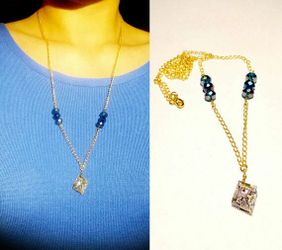 Necklace with handmade silver colored with purple accents bismuth crystal pendant and roundelle faceted blue beads